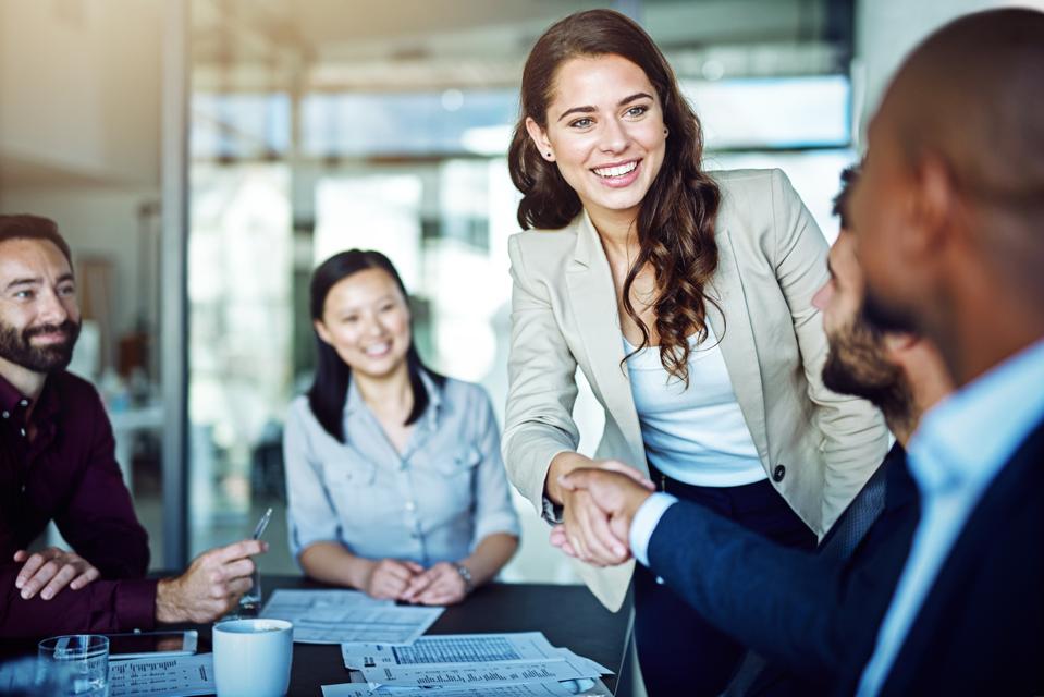 Leadership Initiative Creates Career Growth Opportunities Professional taking initiative by introducing herself during a business meeting, demonstrating leadership, confidence, networking, and career growth.