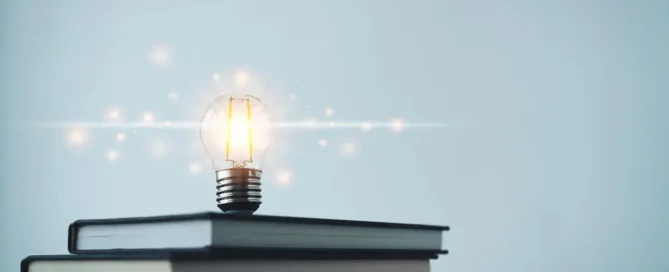 Light bulb on stacked books representing business innovation, leadership development, strategic thinking, and continuous learning.